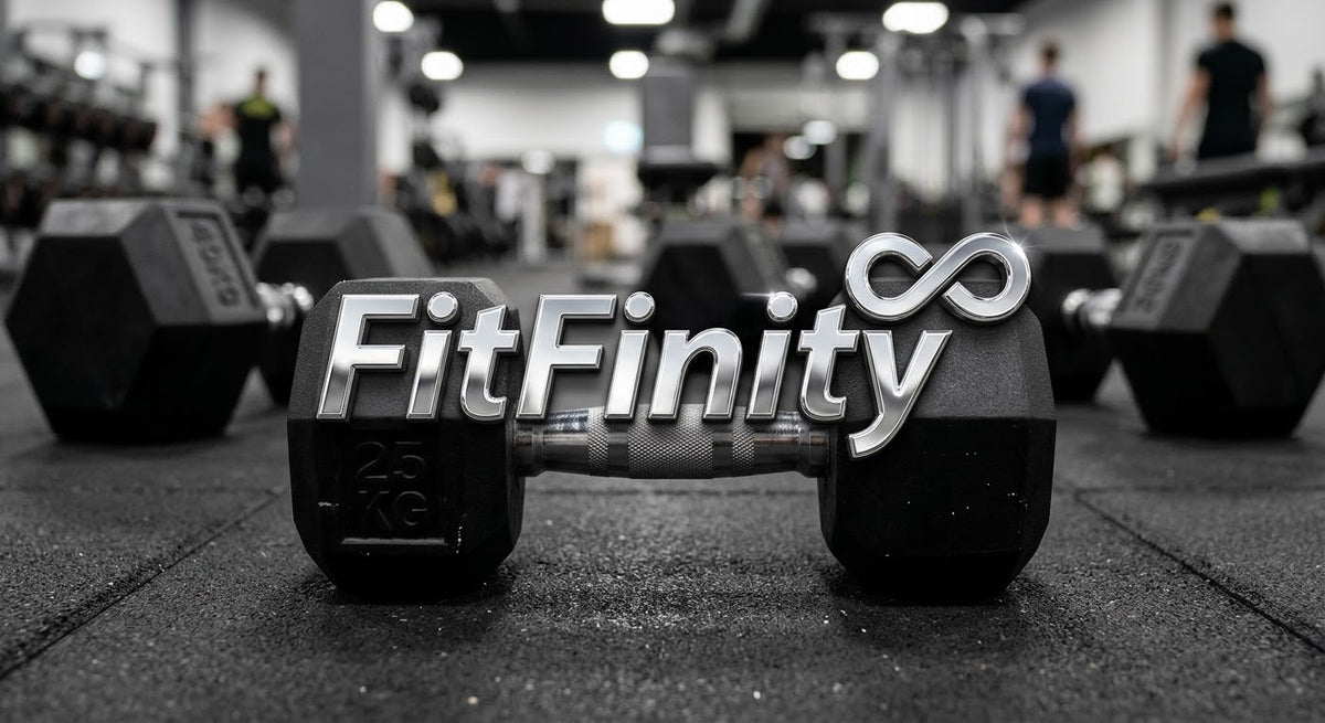 A pair of black hex dumbbells on a gym floor, with the brand name 'FitFinity' prominently displayed across the bar in metallic silver letters. The background shows a blurred gym interior with other weights and people working out.